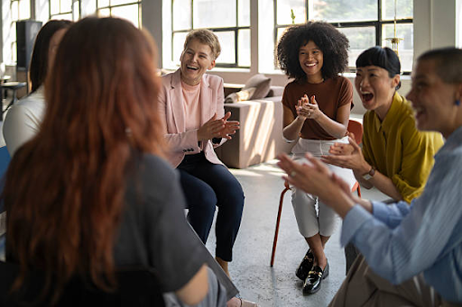 Group therapy session with people sitting in a circle during an addiction recovery support meeting