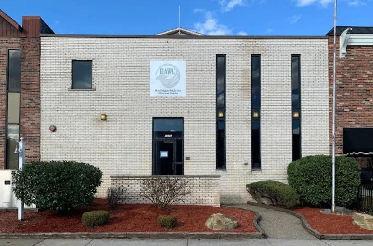 The exterior of the Huntington Addiction Wellness Center (HAWC) building, a two-story white brick facility.