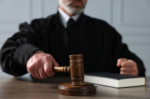 Judge holding a gavel in a courtroom during a legal proceeding involving rehabilitation or sentencing
