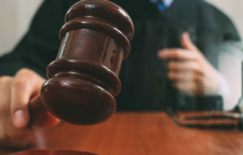 Judge holding a gavel in a courtroom during a legal proceeding involving rehabilitation or sentencing