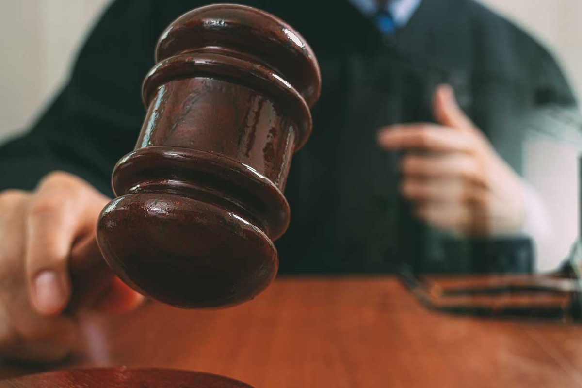 Judge holding a gavel in a courtroom during a legal proceeding involving rehabilitation or sentencing